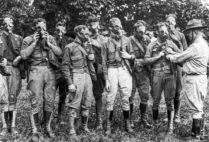 Black & white photo of soldiers wearing breathing equipment