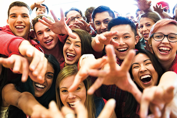 Smiling and laughing fans reach out their hands
