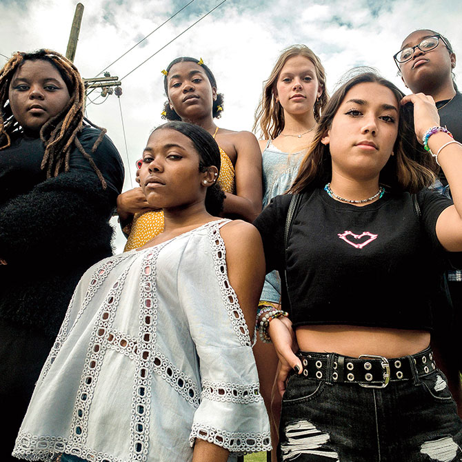 A group of young women posing with confident stern expressions