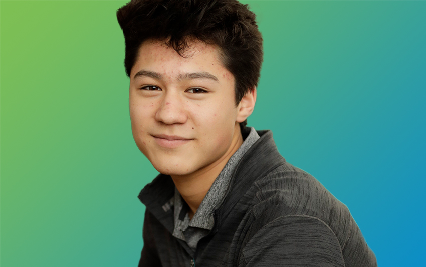 A boy wearing a gray lightweight workout jacket smiling