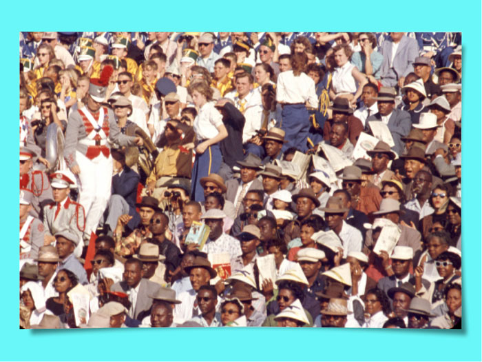 A large audience split down the middle with Black people on one side and White people on the other