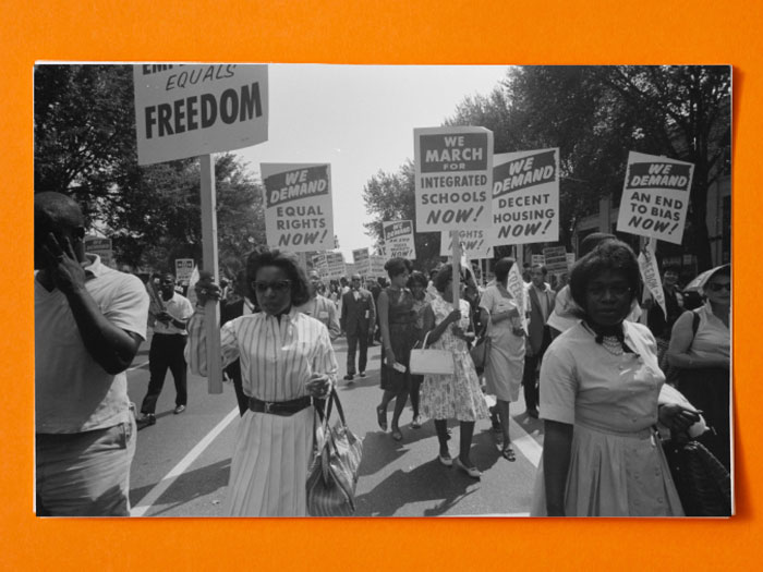 Black and white photo of people protesting with picket signs for integration and equal rights