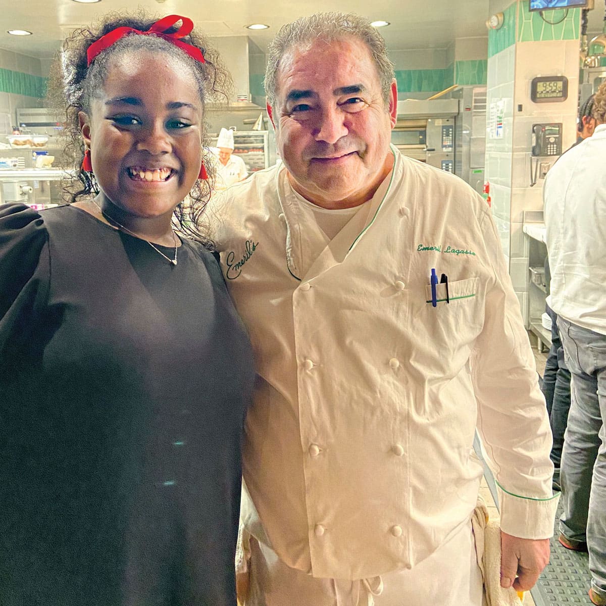 A smiling girl posing next to a famous chef