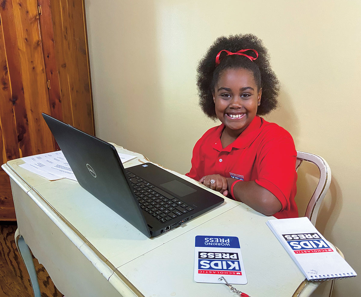 A  girl sitting at a table in front of a laptop