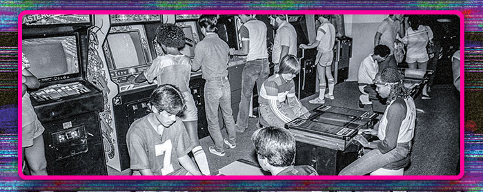black and white photo of kids playing at an arcade