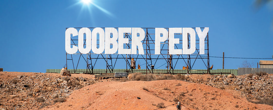 a desert with a sign that reads "Coober Pedy"