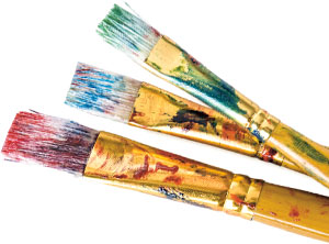 Three paint covered paint brushes