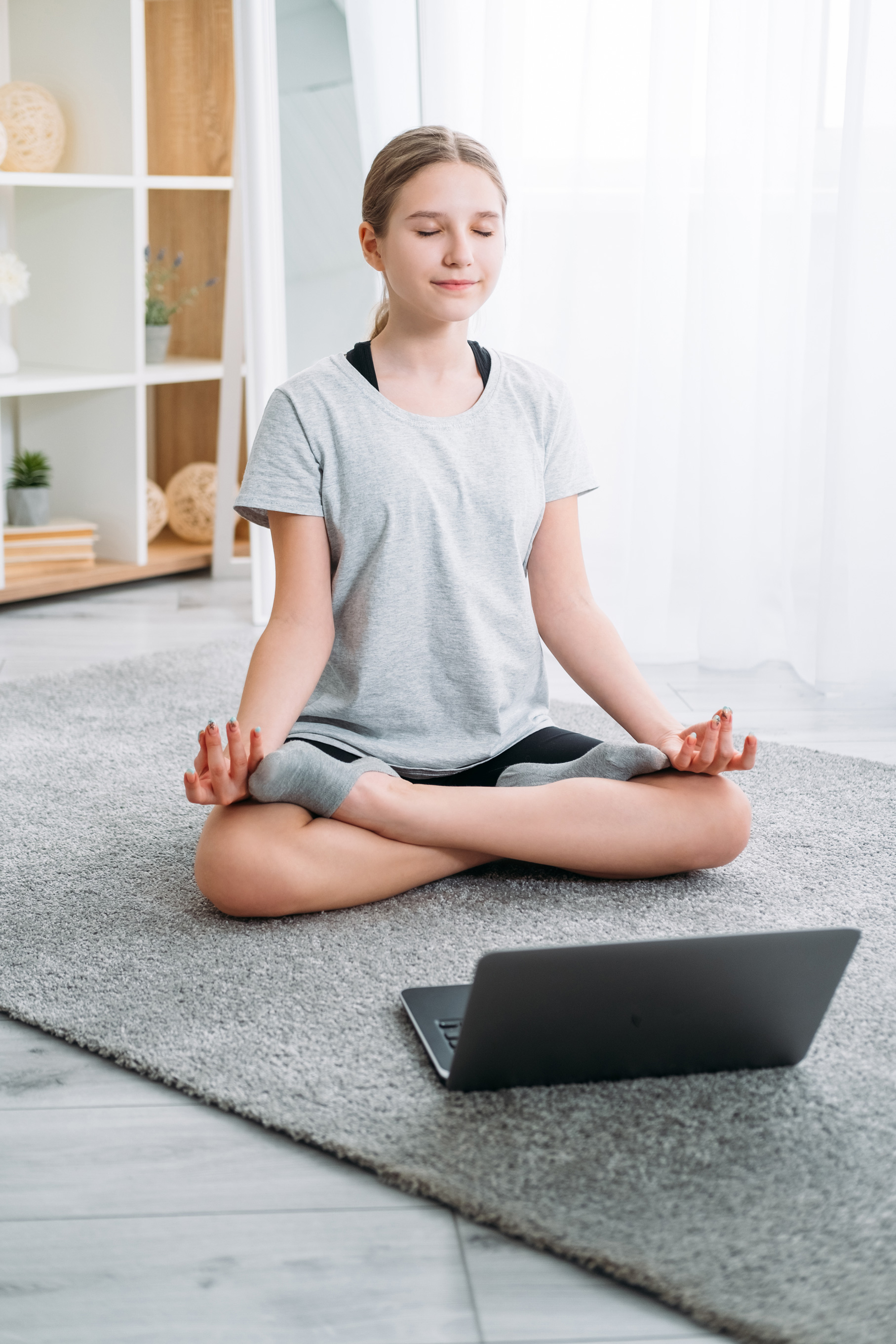 Photo of a teen meditating in front of a computer