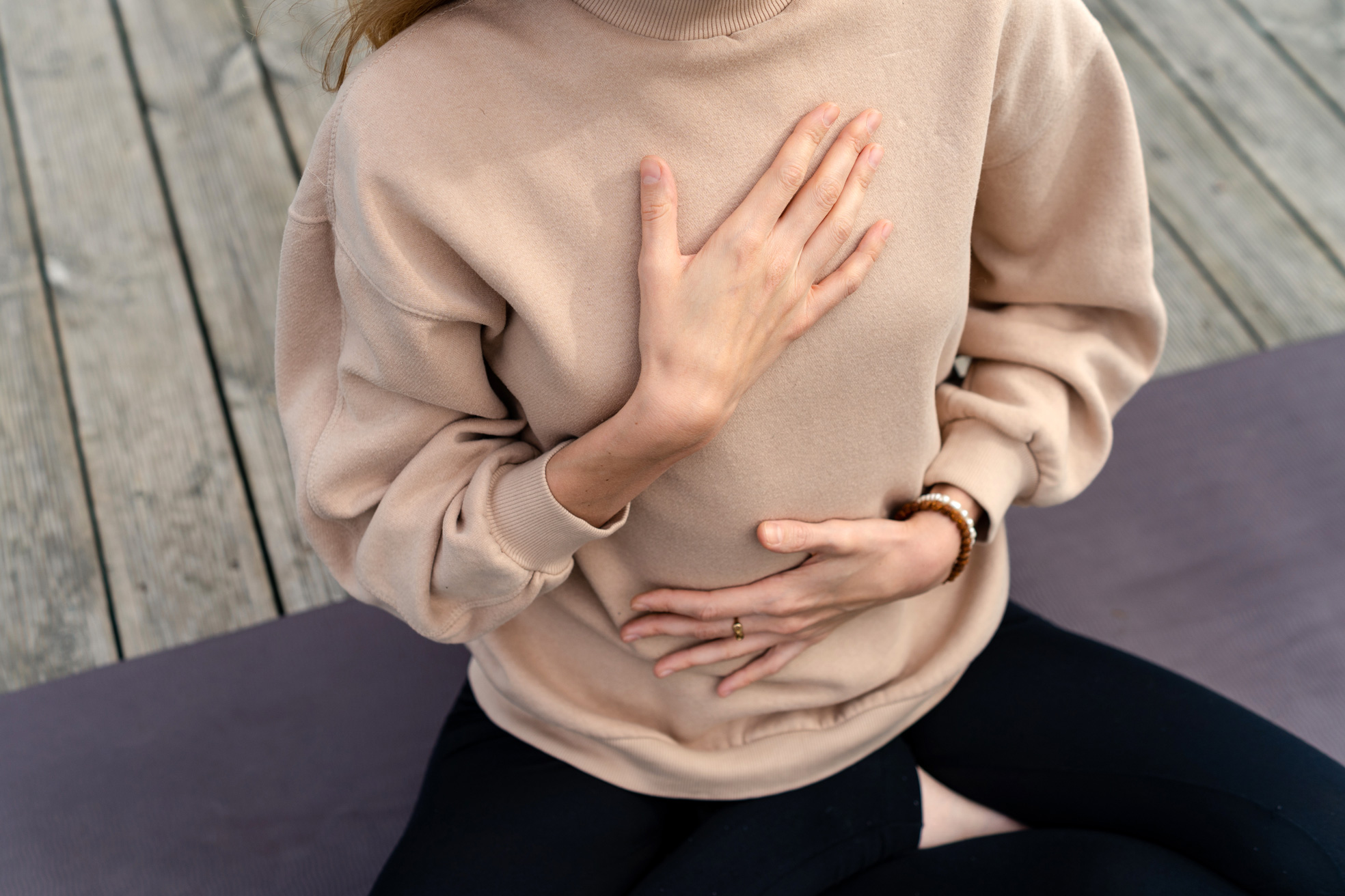 Photo of a person resting their hands on their belly and chest