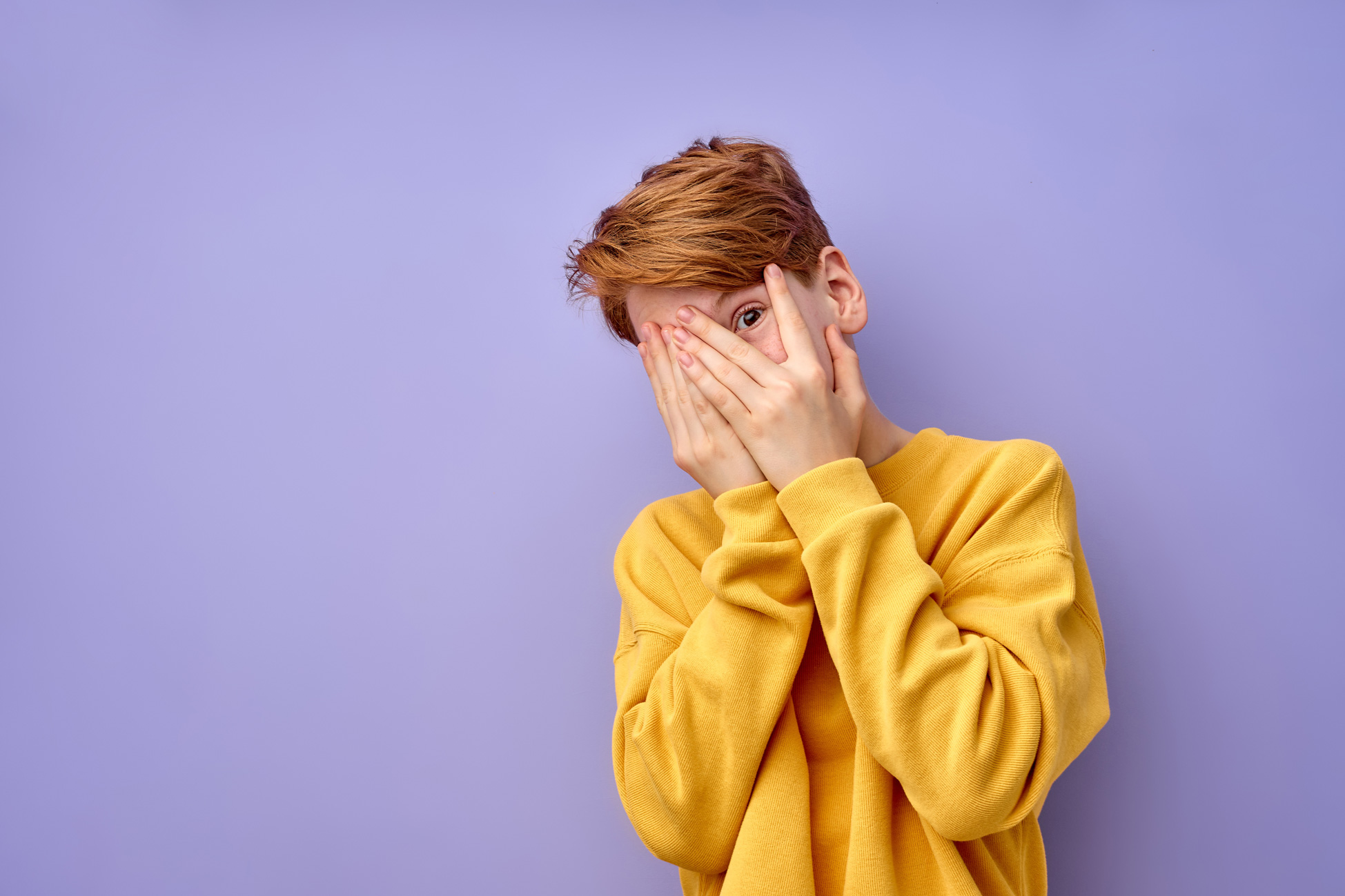 Photo of a teen trying to hide their face with their hands