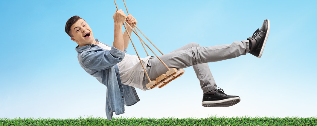 Image of a person smiling on a wooden swing