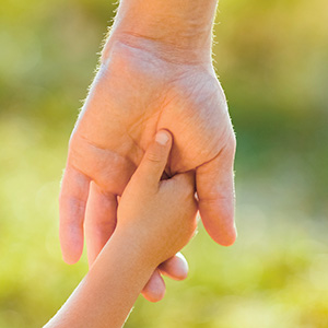 Image of a small hand holding a larger hand