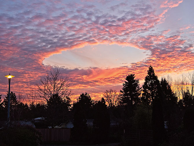 Enlargeable photo of the sky as the sun sets and the clouds open into a perfect circle