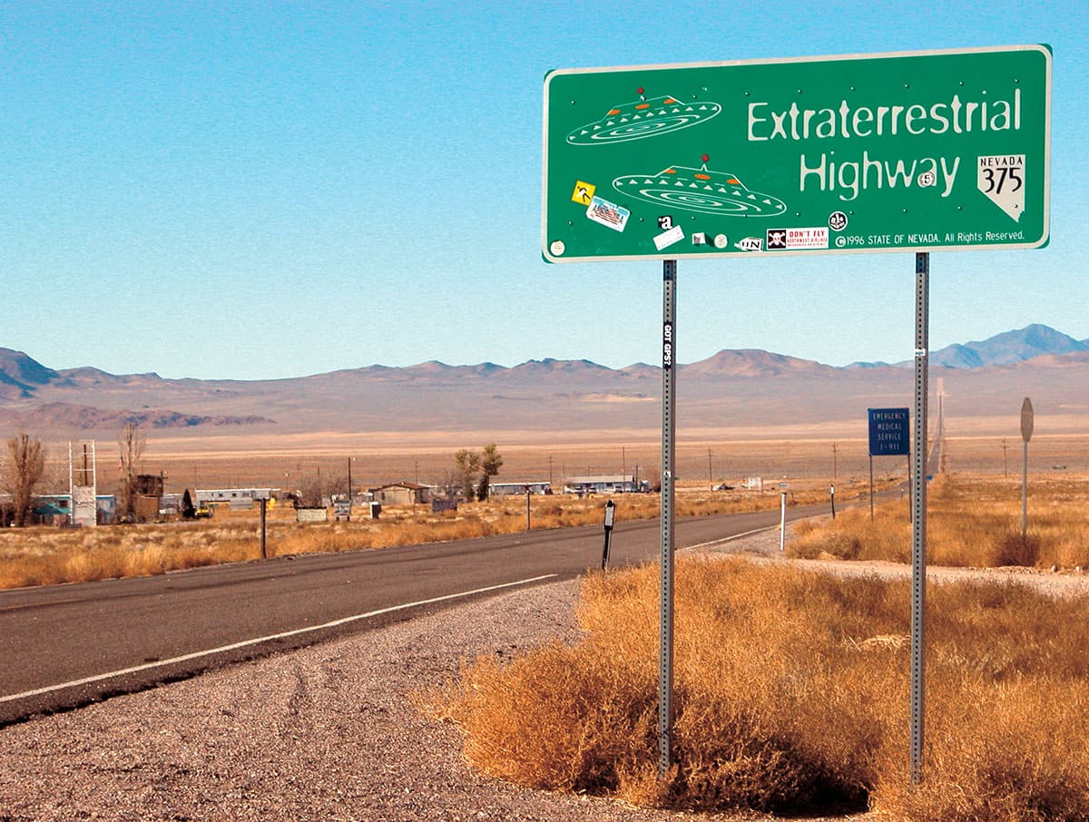 Highway in the desert with a sign saying "Extraterrestrial Highway"