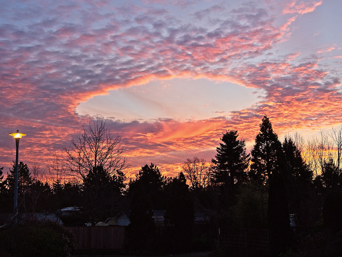 Enlargeable photo of the sky as the sun sets and the clouds open into a perfect circle