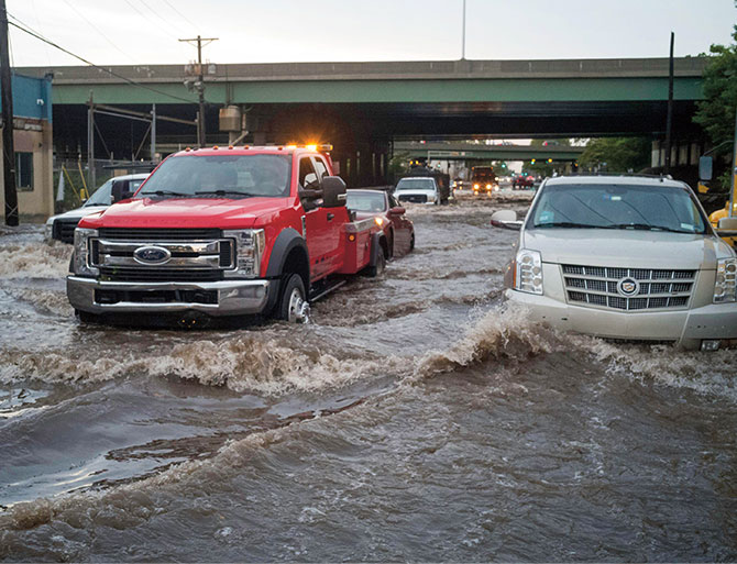 Enlargeable photo of cars driving through high flood waters