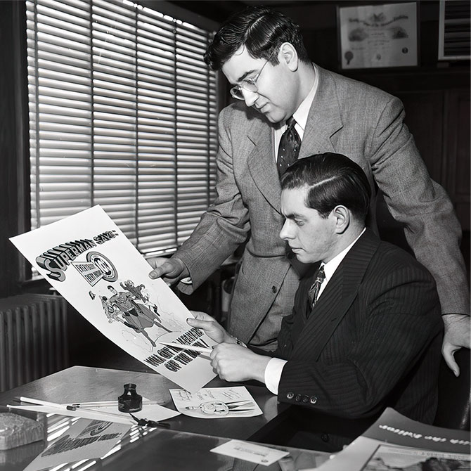 Enlargeable black and white photo of two men in suits looking over a poster with Superman on it